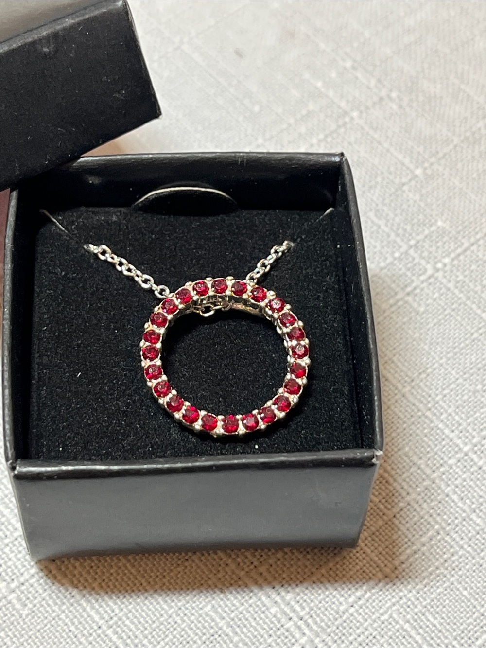 New Avon Silver-Tone Circle Pendant with Red Crystals
Box included
